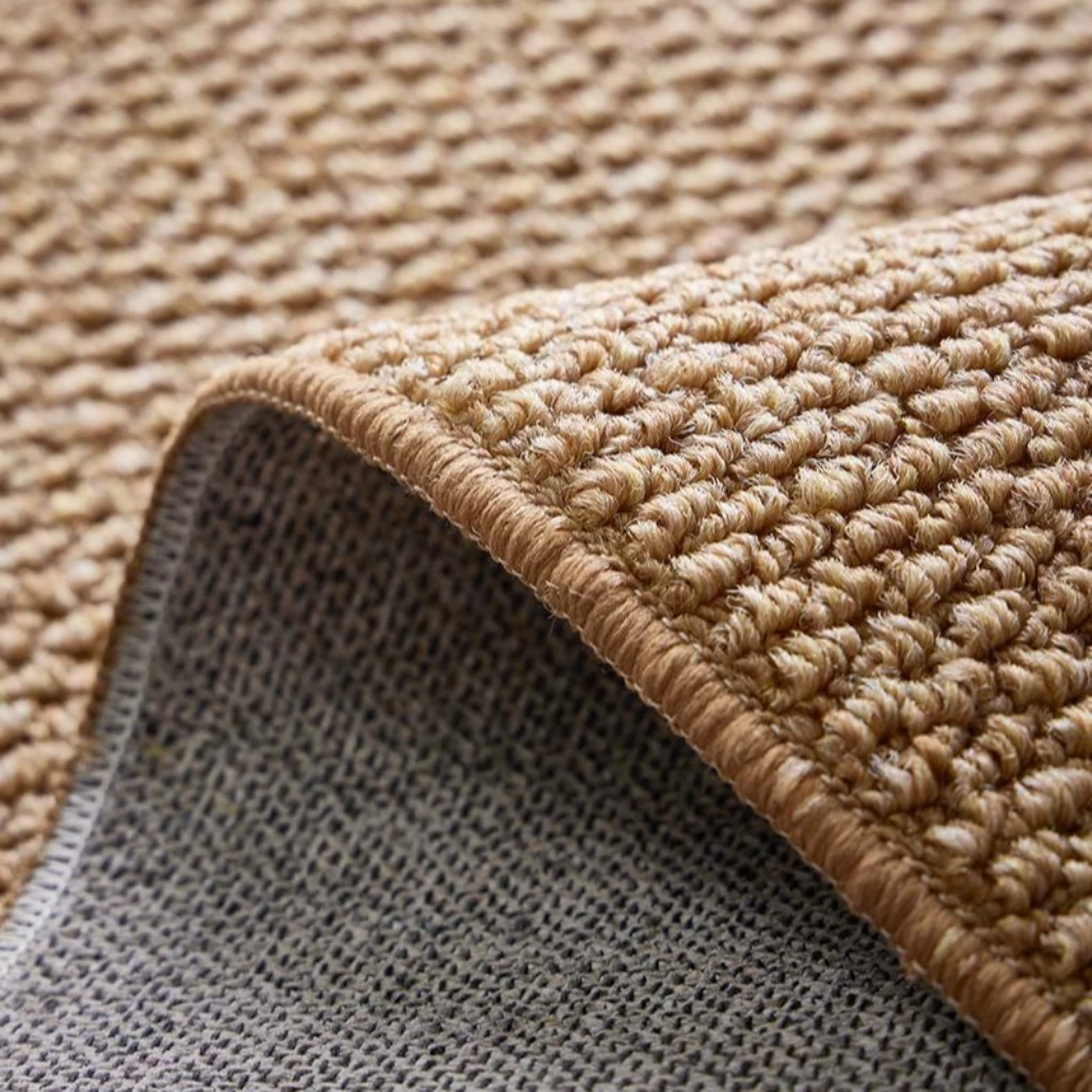 Close-up of a natural beige woven rug with a textured, sisal-style surface and a soft gray backing, showcasing durable craftsmanship for harmonious pet living.